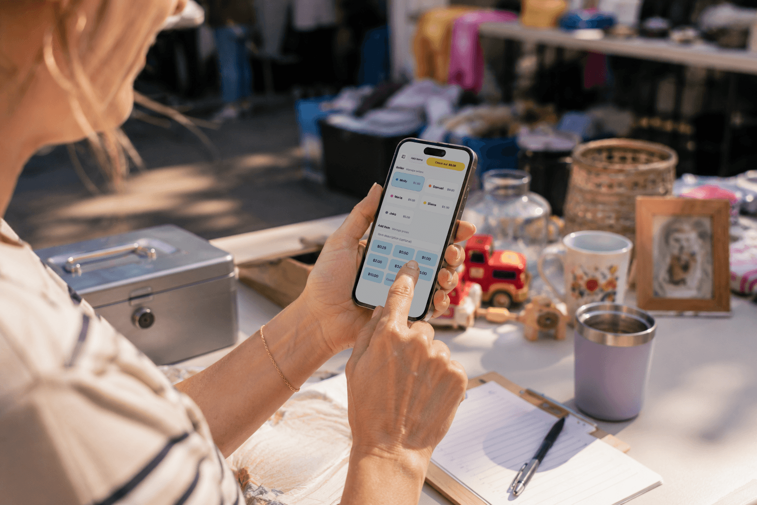 Shopper using SaleBuddy checkout on a phone at a garage sale table